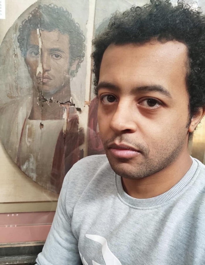 A modern Egyptian man taking a selfie with a 2000 years old portrait of an Egyptian man during the Roman era - meme