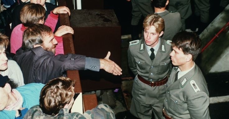 Policiais de fronteira da Alemanha Oriental recusando-se a apertar a mão de um alemão da fronteira ocidental por cima da cerca da fronteira em novembro de 1989 - meme