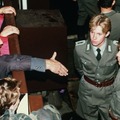 Policiais de fronteira da Alemanha Oriental recusando-se a apertar a mão de um alemão da fronteira ocidental por cima da cerca da fronteira em novembro de 1989