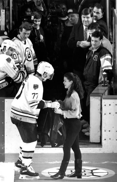 Figure skater Nancy Kerrigan receives a Boston Bruins jacket from player Ray Bourque at the Boston Garden on Feb. 3, 1994 - meme
